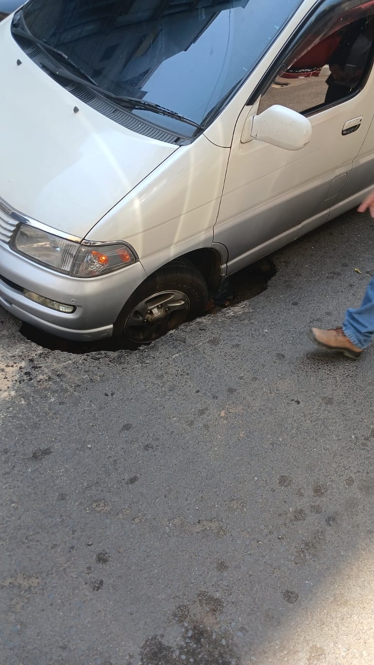 Rueda de una camioneta de gran porte quedó atrapada en un pozo que se abrió en la capa asfáltica de la calle Oliva de Asunción.