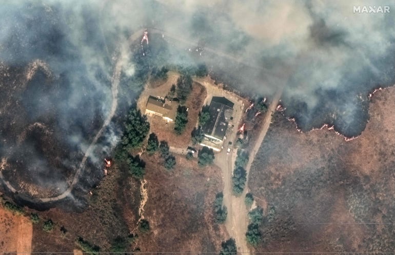 Esta imagen satelital proporcionada por Maxar Technologies muestra un incendio que rodea las casas cerca de Moorpark, California.