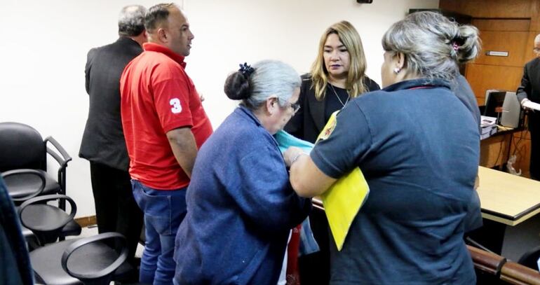 Una guardiacárcel esposa a Ilda Arca de Aquino tras conocer el fallo condenatorio, en marzo del 2019. A su lado, su hijo, César Aquino, y de espaldas, Ramón Jara Acosta. Archivo Abc.