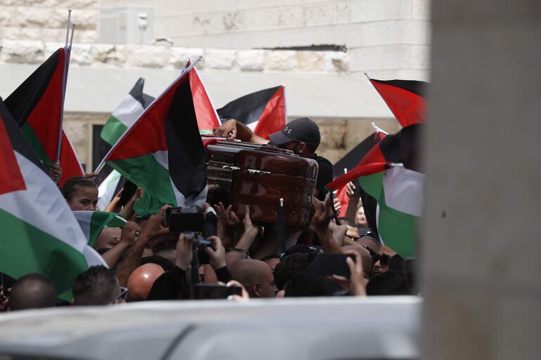 -FOTODELDÍA- JERUSALEM, 13/05/2022.- Varias personas llevan el féretro de la periodista estadounidense-palestina asesinada, Shireen Abu Akleh, frente al Hospital San José, antes de la procesión fúnebre en la Ciudad Vieja de Jerusalén, este viernes. La periodista de Al Jazeera Shireen Abu Akleh fue asesinada el 11 de mayo durante una redada de las fuerzas israelíes en la ciudad cisjordana de Yenín.EFE/ Atef Safadi
