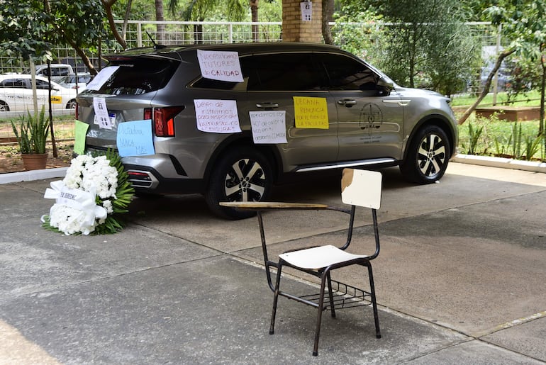 La camioneta de "oro" del Decanato de Derecho UNA fue adornado con una corona de rosas y pancartas de protesta por los estudiantes.