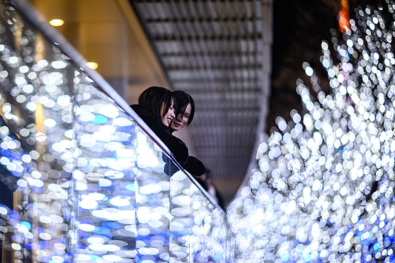 Dos personas observan luces navideñas en Tokio, Japón.