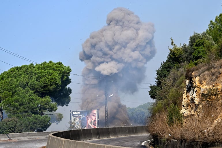 El humo se eleva tras una explosión controlada realizada por el ejército libanés en el lugar de un ataque aéreo israelí contra un vehículo en la ciudad de Kahaleh, Líbano,