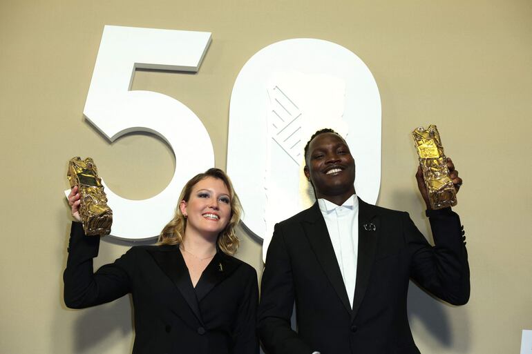 La actriz francesa Maiwene Barthelemy y el actor guineano Abou Sangare posan con sus premios como intérpretes revelación.