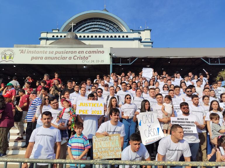 Exfuncionarios de Itaipú llegaron a la Basílica con carteles pidiendo una respuesta del presidente de la República