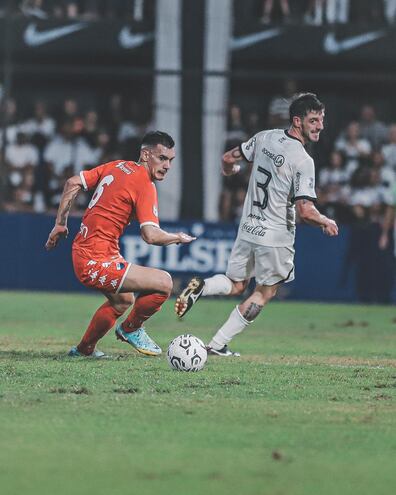 Fernando Román, de Nacional, disputa el balón con Alejandro Silva, exjugador de Olimpia.