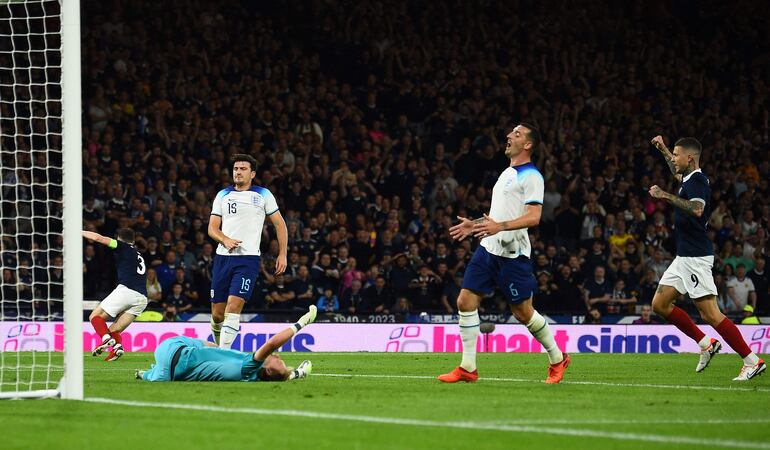 El escocés Andrew Robertson (i) sale a celebrar tras el gol en contra anotado por el zaguero inglés Harry Maguire (N° 16), durante el partido amistoso que Inglaterra ganó 3-1.