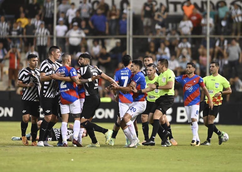 Los futbolistas de Libertad y Cerro Porteño en medio de un altercado durante el clásico por la jornada 19 del torneo Clausura 2023 del fútbol paraguayo en el estadio La Huerta, en Asunción.