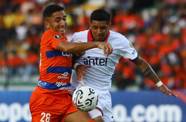 Puerto Cabello's Argentine defender Facundo Cobos (L) and Nacional's Paraguayan forward Antonio Galeano (R) fight for the ball during the Copa Libertadores' second round first leg football match between Venezuela's Puerto Cabello and Uruguay's Nacional at the Misael Delgado stadium in Valencia, Venezuela on February 21, 2024. (Photo by Juan Carlos Hernandez / AFP)