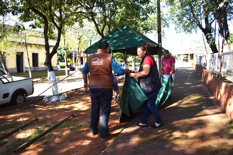 La jefa de la ALAT de Acahay, Blanca Giménez, y funcionarios de la DEAg tuvieron que desmotar los toldos que iban a ser utilizados para una feria agropecuaria.