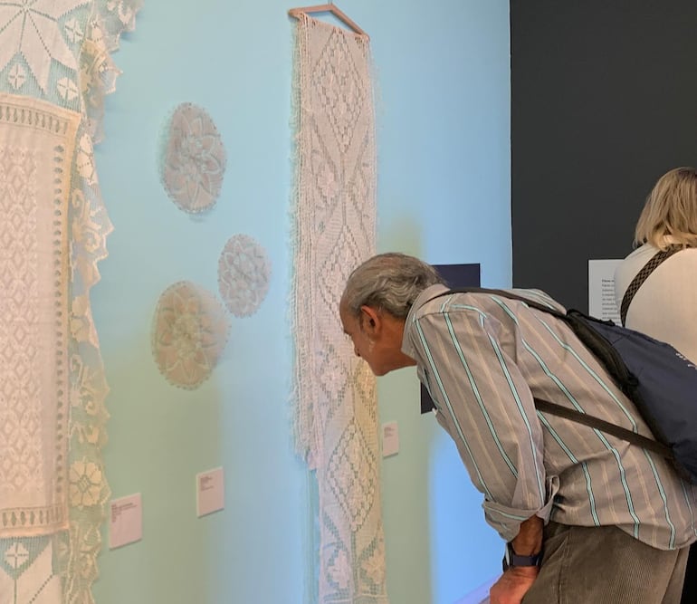 Un visitante observa los tejidos de encaje ju y ñanduti que se exhiben en la Casa da América Latina en Portugal.