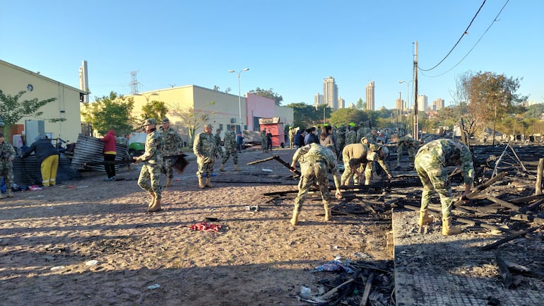 Militares trabajan con la Secretaría de Emergencia Nacional para la limpieza y reconstrucción de precarias viviendas en uno de los refugios ubicados en la zona Costanera de Asunción.