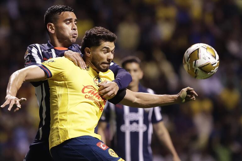 MEX7903. PUEBLA (MÉXICO), 12/12/2024.- Henry Martín (d) de América disputa el balón con Brandon Vázquez de Monterrey, este jueves durante el partido de ida de la final del torneo Apertura 2024 de la Liga MX, en Puebla (México). EFE/ Hilda Ríos
