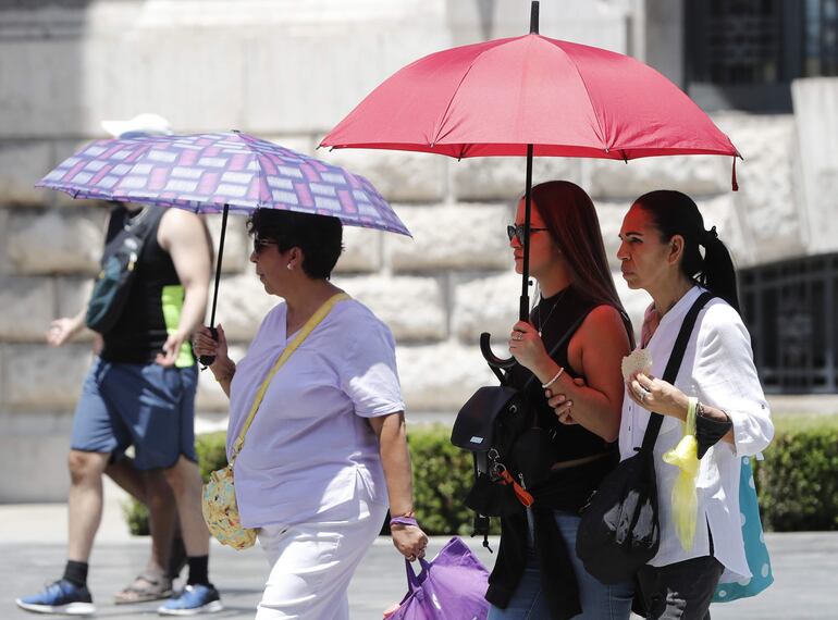 Varias personas se protegen del sol este viernes en Ciudad de México (México).