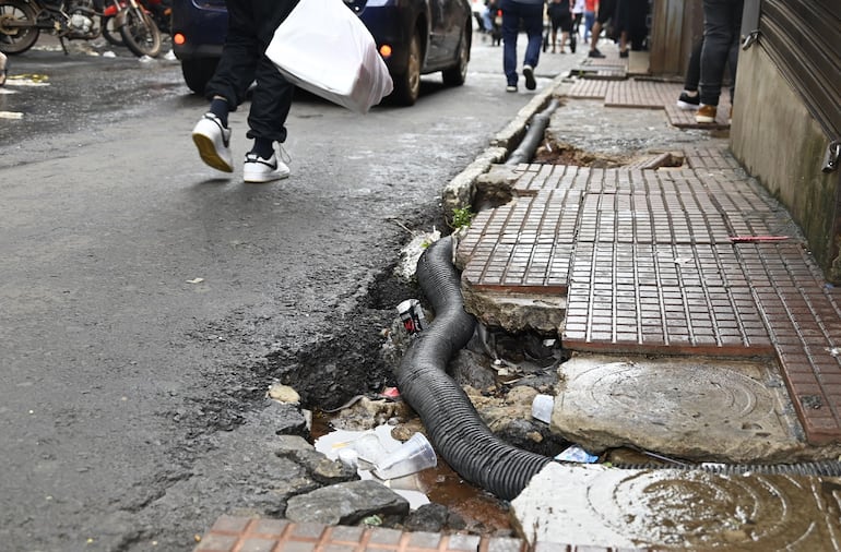 Visitantes deben circular por una vereda destrozada en la avenida Adrían Jara. 