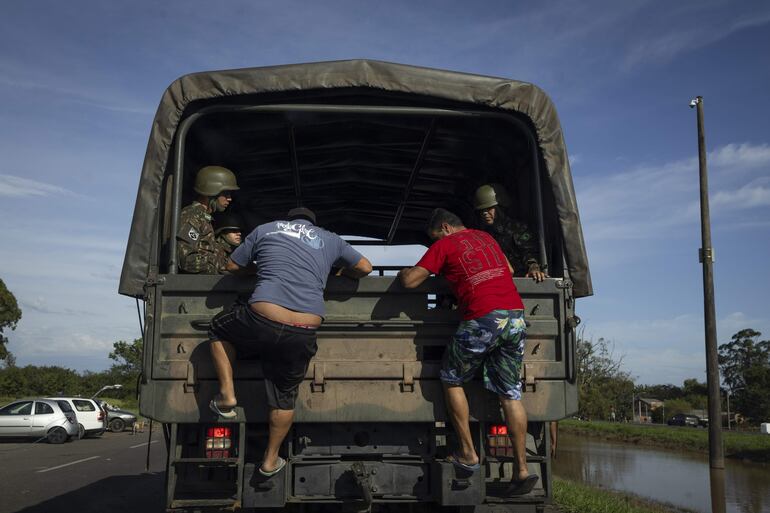 Un camión del Ejército ayuda a personas damnificadas por las inundaciones este miércoles, en la ciudad de Eldorado do Sul, región metropolitana de Porto Alegre (Brasil). El balance oficial de este temporal, que comenzó hace unas semanas, agrega también 129 desaparecidos y 372 heridos en el propio Río Grande do Soul, donde el 80 % de los municipios está total o parcialmente bajo el agua y unas 230.500 personas han tenido que abandonar sus hogares.