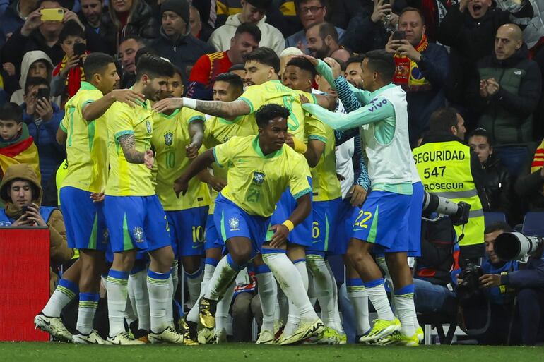 Los jugadores de Brasil celebran el gol de Endrick Felipe Moreira (c) durante el partido amistoso que las selecciones nacionales de fútbol de España y Brasil disputaron el martes 26 de marzo de 2024, en el estadio Santiago Bernabéu, en Madrid (España). Después de uno de los peores años de su historia, la selección brasileña salió de la UCI gracias a la irrupción goleadora de Endrick, la capacidad de reacción del grupo y el nuevo aire que le ha dado el técnico debutante Dorival Júnior, a tres meses de la Copa América.