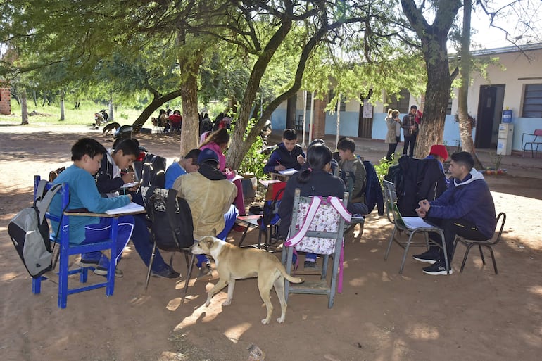 Estudiantes soportaban el intenso frío de ayer en la clase de Ciencias Naturales a la intemperie, bajo árboles sin aulas en la escuela Nueva Asunción de Chaco´i.