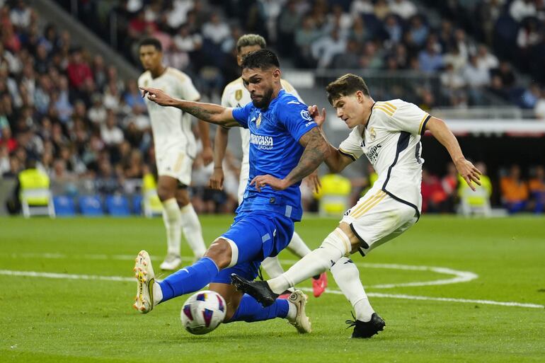 El defensa paraguayo del Getafe Omar Alderete (i) disputa un balón con Fran García (d), defensa español del Real Madrid, durante el partido correspondiente a la jornada 4 de LaLiga que Real Madrid y Getafe SAD disputan este sábado en el Santiago Bernabéu. 