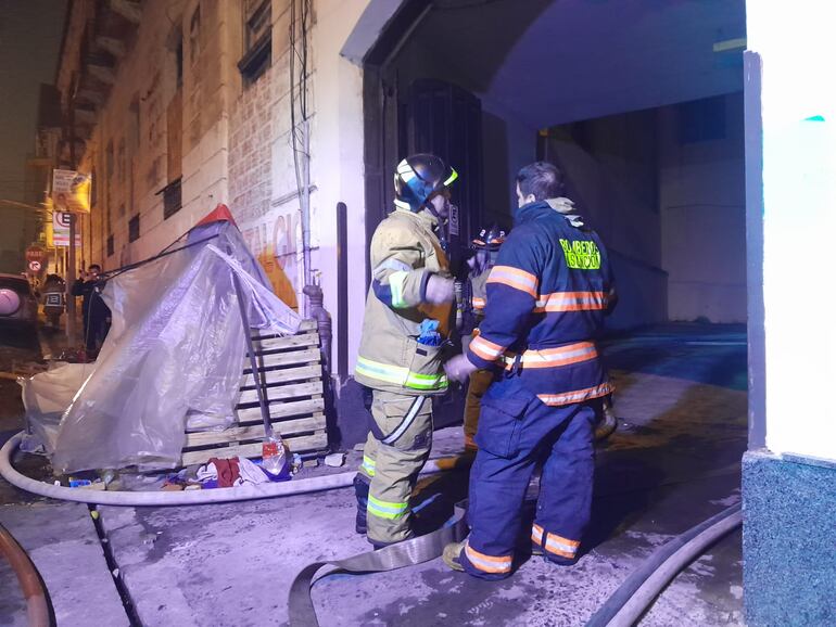 Bomberos voluntarios trabajan en el control de las llamas del incendio en la Caja de Jubilaciones y Pensiones del Personal Municipal