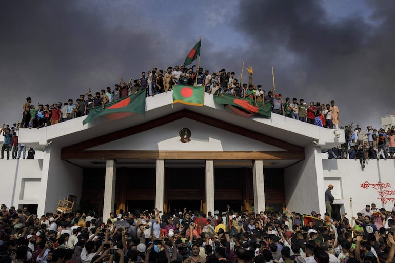 Una multitud reunida en la residencia de la ex primera ministra derrocada de Bangladés, el pasado lunes.