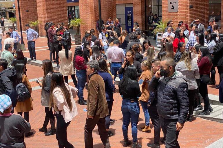 Personas se reúnen afuera de un edificio luego de ser evacuadas tras un temblor de 6.1 hoy, en Bogotá (Colombia).  Un temblor de magnitud 6,1 sacudió al mediodía de este jueves buena parte de Colombia, sin que hasta el momento las autoridades hayan informado de víctimas o daños.