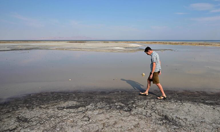 Un hombre camina junto a la orilla del Gran Lago Salado en Salt Lake City, Utah (Estados Unidos), que registra niveles anormalmente bajos.
