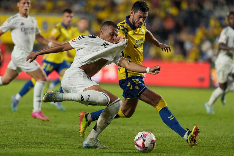 TOPSHOT - Real Madrid's French forward #09 Kylian Mbappe fights for the ball with Las Palmas' Scottish defender #15 Scott McKenna during the Spanish league football match between UD Las Palmas and Real Madrid CF at the Gran Canaria stadium in Las Palmas de Gran Canaria on August 29, 2024. (Photo by Cesar Manso / AFP)