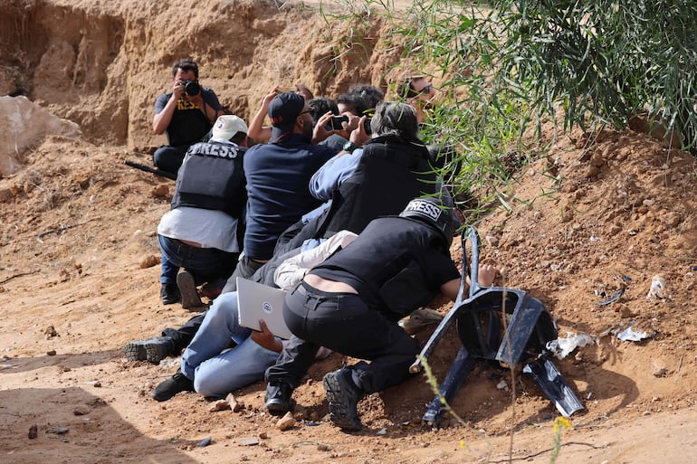 Periodistas se cubren ante la advertencia de un lanzamiento de misiles en la frontera entre la Franja de Gaza e Israel, el pasado 22 de noviembre.