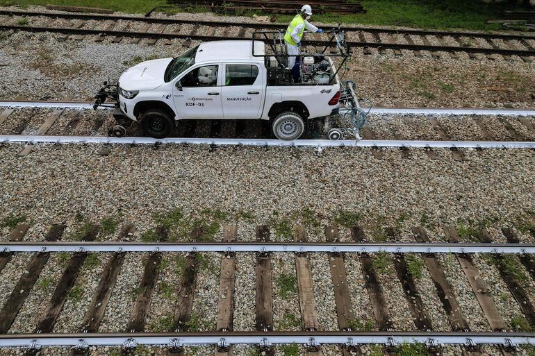 Empleados de ViaMobilidade, una empresa que gestiona las líneas de metro y tren en el área metropolitana de São Paulo, trabajan en la pintura de las vías férreas en Osasco, estado de São Paulo, Brasil.