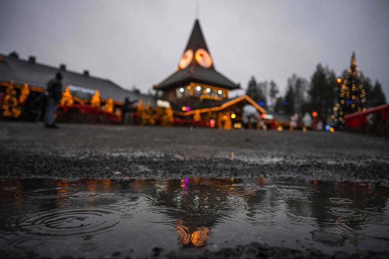 La lluvia cae mientras los turistas visitan el Pueblo de Santa Claus, cerca de Rovaniemi, en Laponia finlandesa. A un mes de la Navidad, Santa Claus está ocupado preparándose, pero el calentamiento climático y la falta de nieve en su ciudad natal ártica lo tienen preocupado.