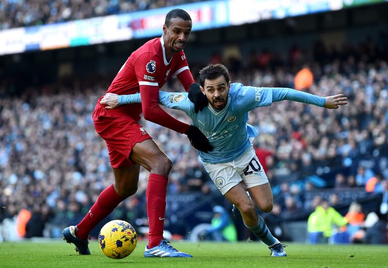 Joel Matip (i), futbolista del Liverpool, pelea con Bernardo Silva, jugador del Manchester City, en el partido por la jornada 13 de la Premier League de Inglaterra en el Etihad Stadium, en Manchester, Inglaterra.