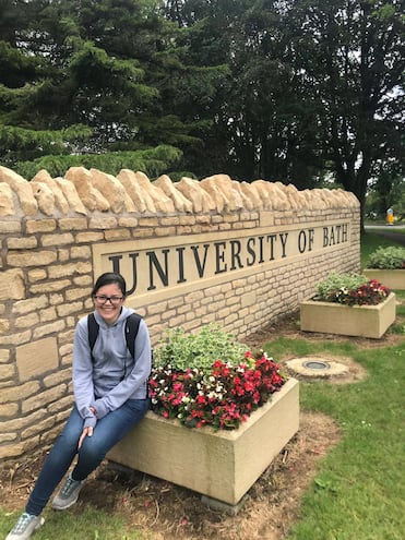 Laura Oporto posa en la entrada de la Universidad de Bath, Inglaterra donde obtuvo su doctorado en matemáticas.