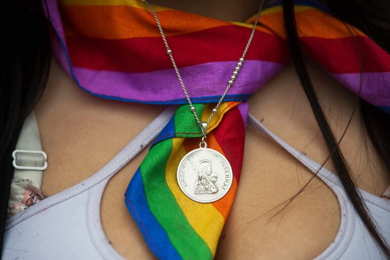 Una participante del Día del Orgullo en Santiago de Chile lleva un pañuelo con los colores del arcoíris atado al cuello, con una medalla de la Virgen de Montserrat. 