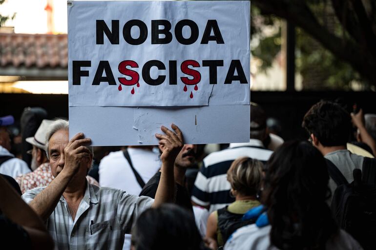  "Noboa Fascista" se lee en un cartel expuesto por un manifestante en las afueras de la Embajada de Ecuador en México. 