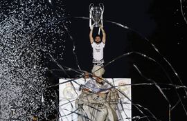 Nacho Fernández, jugador del Real Madrid, levanta el trofeo de la Champions League en la Plaza de Cibeles durante las celebraciones de campeón con los aficionados.
