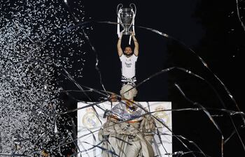 Nacho Fernández, jugador del Real Madrid, levanta el trofeo de la Champions League en la Plaza de Cibeles durante las celebraciones de campeón con los aficionados.