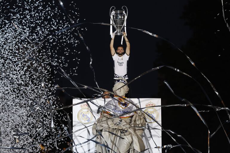 Nacho Fernández, jugador del Real Madrid, levanta el trofeo de la Champions League en la Plaza de Cibeles durante las celebraciones de campeón con los aficionados.