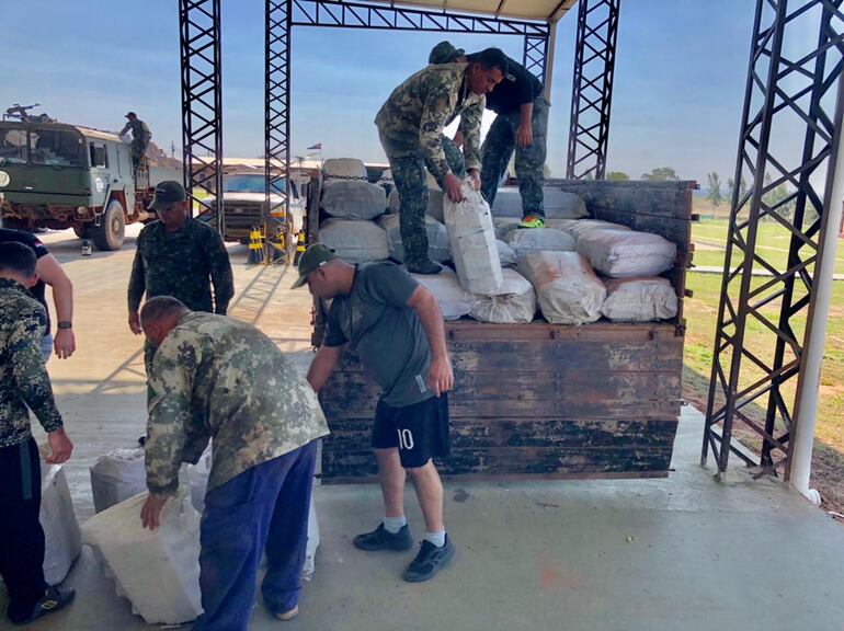 Militares de la FTC procedieron a descargar las bolsas de marihuana para su conteo y pesaje.