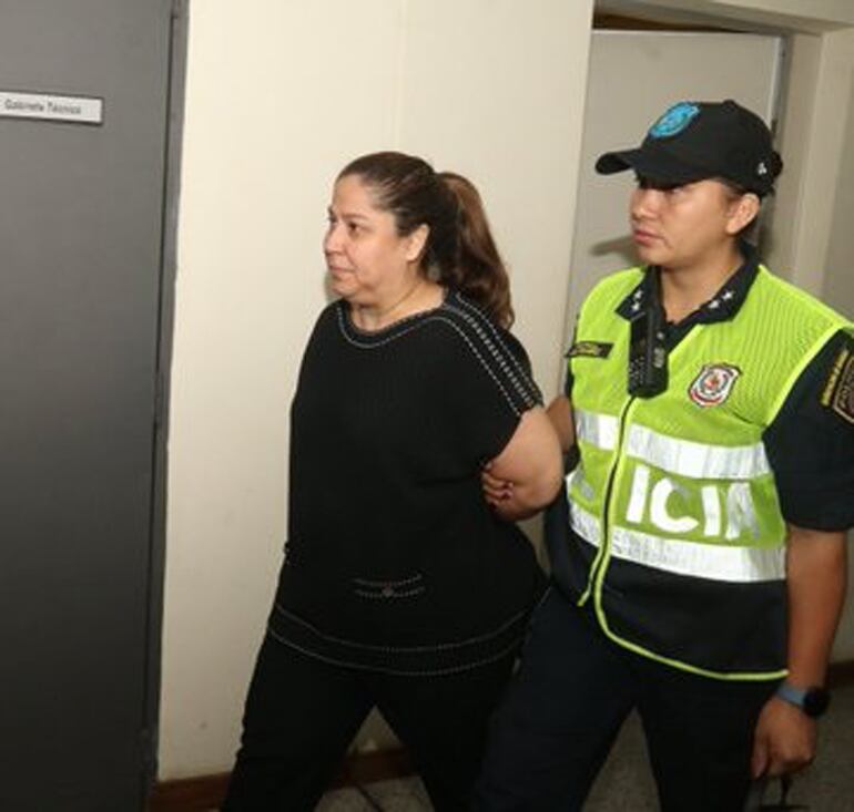 Patricia Samudio es llevada por una agente policial hasta el retén del Palacio de Justicia de Asunción.