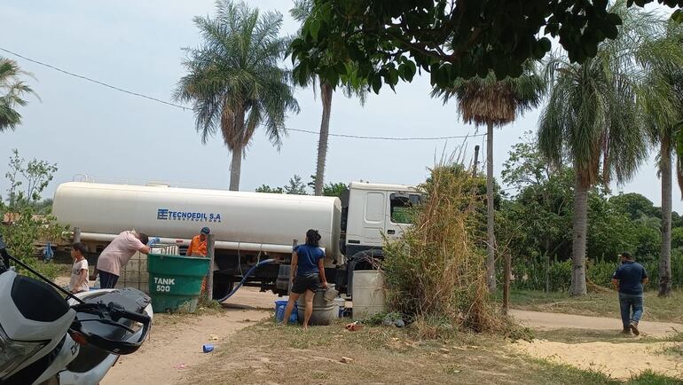 Con apoyo de un camión cisterna se distribuye el agua cruda entre los pobladores de Carmelo Peralta.