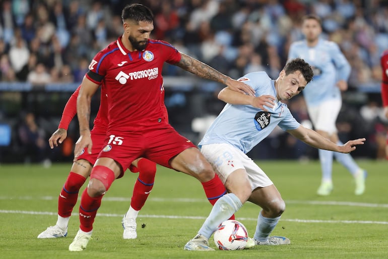 VIGO, 04/11/2024.- El delantero griego del Celta de Vigo Anastasios Douvikas (d) disputa un balón ante el defensa paraguayo del Getafe CF Omar Alderete, durante el encuentro correspondiente a la jornada 12 de Laliga EA Sports que disputan Celta de Vigo y Getafe CF hoy lunes en el estadio de Balaídos, en Vigo. EFE / Salvador Sas
