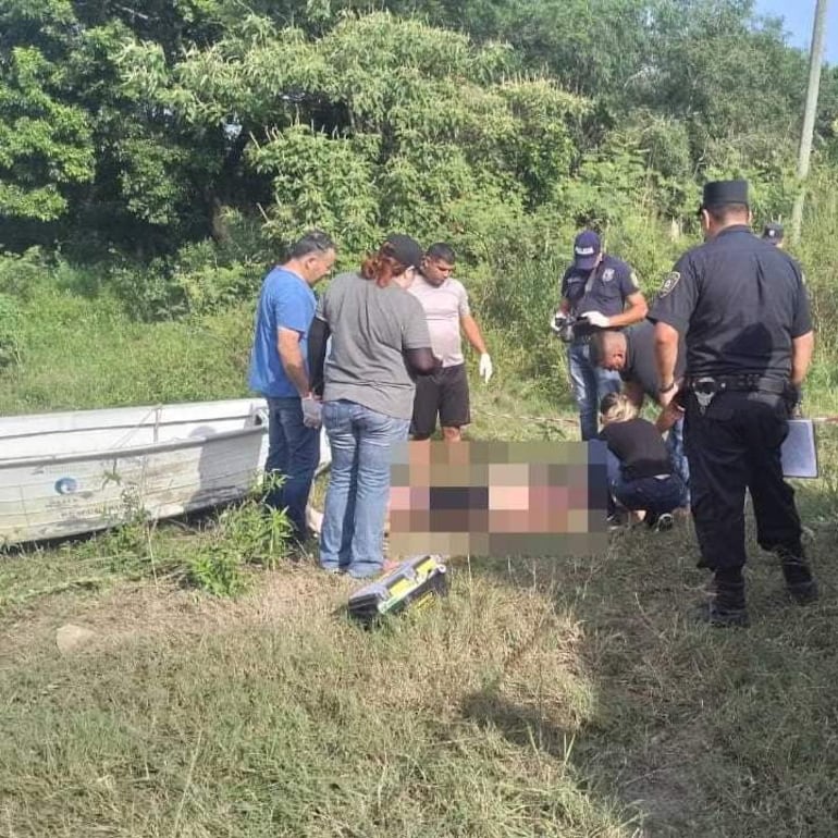 La médica forense Sandra Delvalle inspecciona el cuerpo del joven encontrado en aguas del arroyo Montuoso.