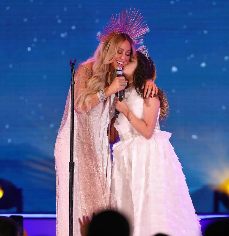 ¡Tierna postal! Mariah Carey recibe emocionada un beso de su hija Monroe, quien la acompañó en el escenario y entonaron villancicos. (Instagram/Mariah Carey)