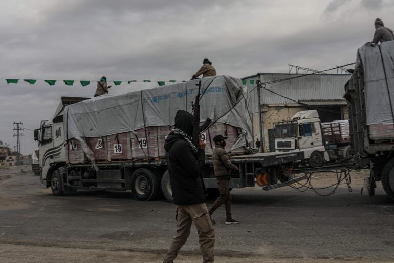 Combatientes de Hamás observan el cruce de camiones con ayuda humanitaria por el paso de Rafah, en la frontera de Gaza con Egipto.