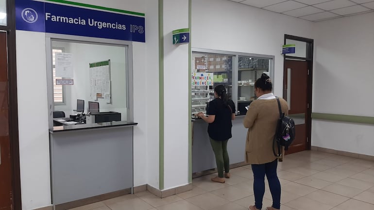 Dos aseguradas del IPS forman fila para obtener medicamentos.