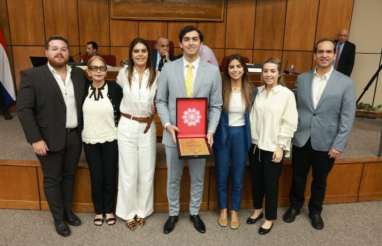 Acompañado por su familia, Diego Domínguez exhibe el reconocimiento del Congreso Nacional.