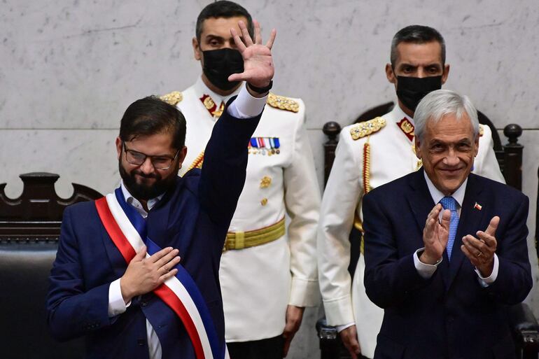 El presidente de Chile Gabriel Boric (i) recibió los atributos presidenciales de la mano del entonces mandatario saliente, Sebastián Piñera. El ex jefe de Estado conservador murió ayer en un accidente aéreo.