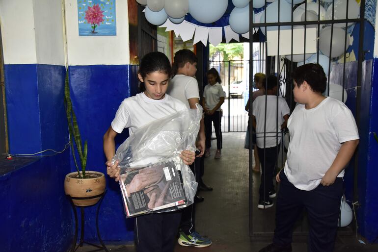 Estudiante de un colegio público de Asunción retira su kit escolar en el primer día de clases.