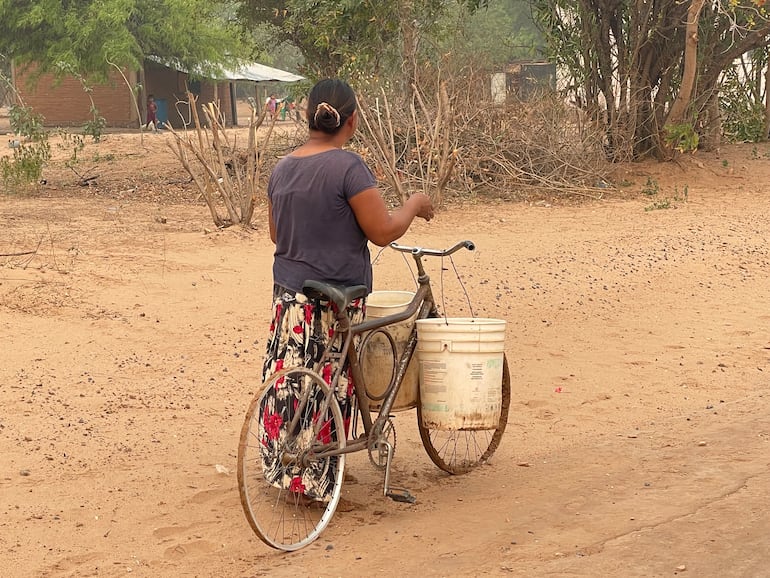 Mujer nativa acarrea agua en la comunidad Laguna Negra.